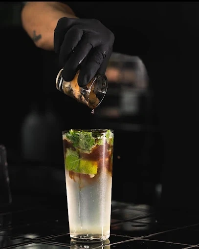 Barista pouring espresso into a tall layered mint mojito glass